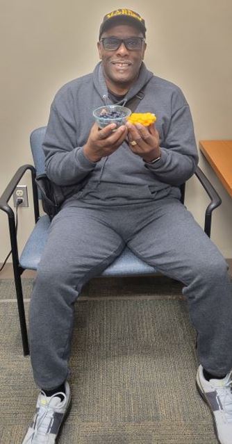 Photo of The Veteran holding a selection of healthy foods.