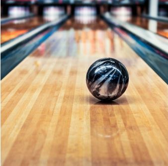 Photo of a black and silver bowling ball rolling down the lane 