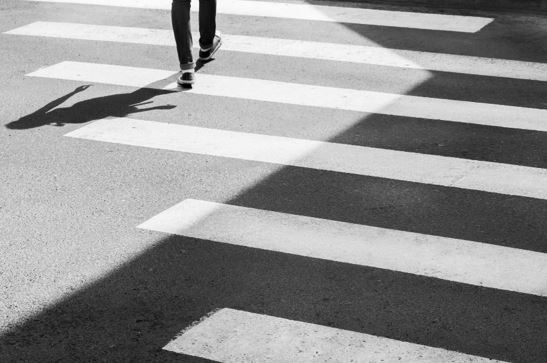 Photo of a person walking away on zebra crossing