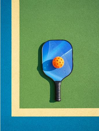 Photo of a pickleball racket and ball