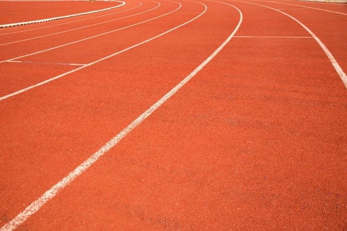 Photo of curved section of an athletics track in a sport stadium
