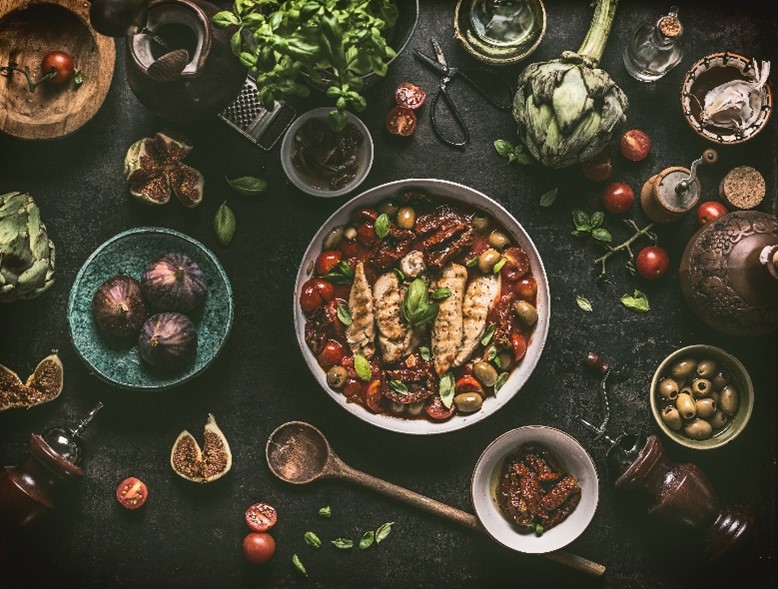 Photo of cooked food with ingredients on a table.