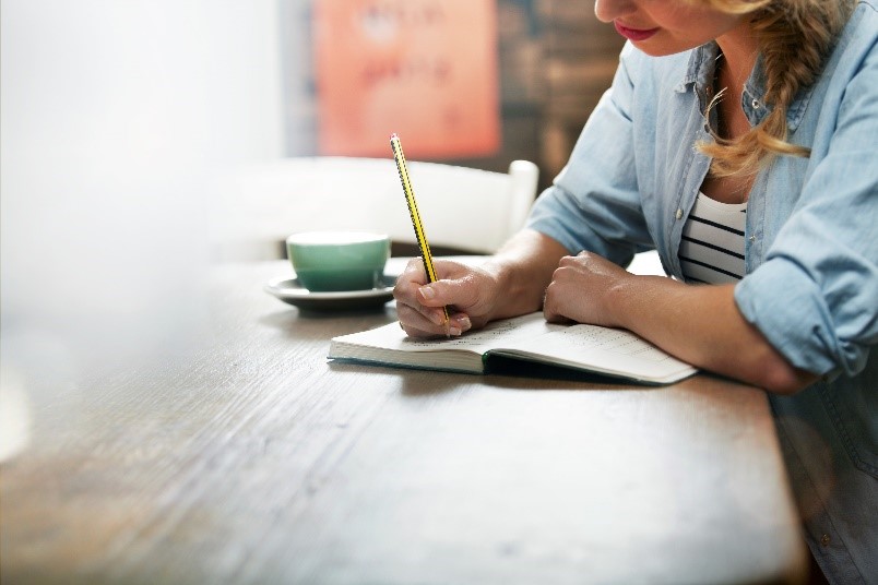 Photo of Person writing in notebook