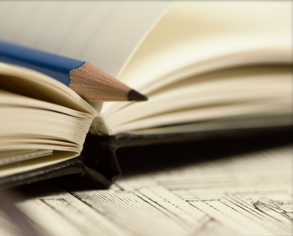 Photo of a pencil in a book with blank pages