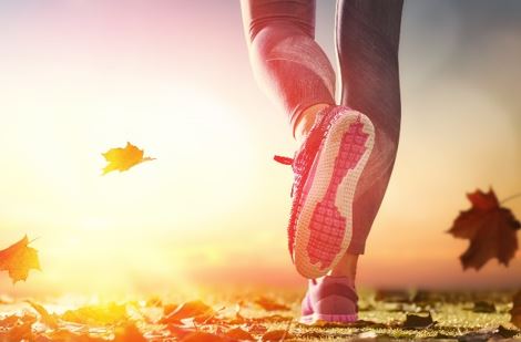 Photo of Person running across leaf littered surface